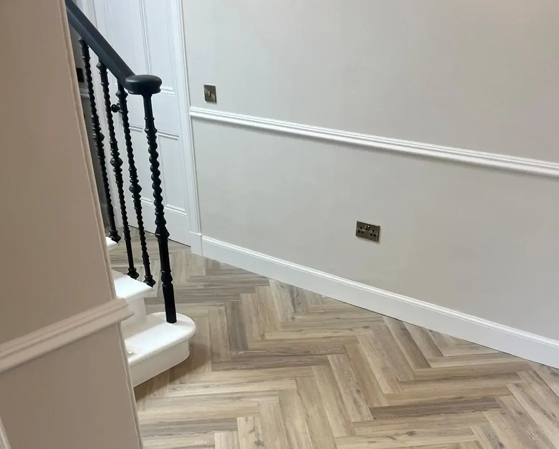 Herringbone hallway floor beside a painted staircase in East Lothian