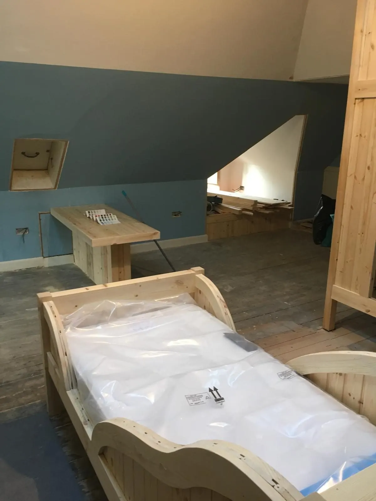 Pine bed and built-in desk in a loft conversion under way in East Lothian