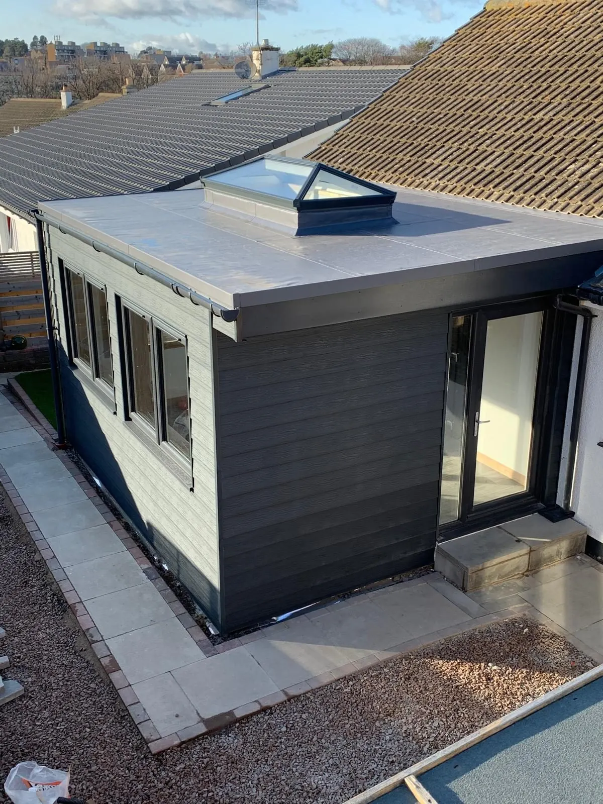 Completed modern clad house extension with rooflights and glazed doors in East Lothian