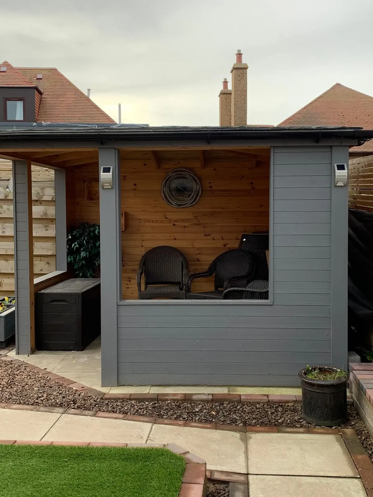 Grey-clad garden shelter with timber-lined seating area built by PAC Joinery and Building
